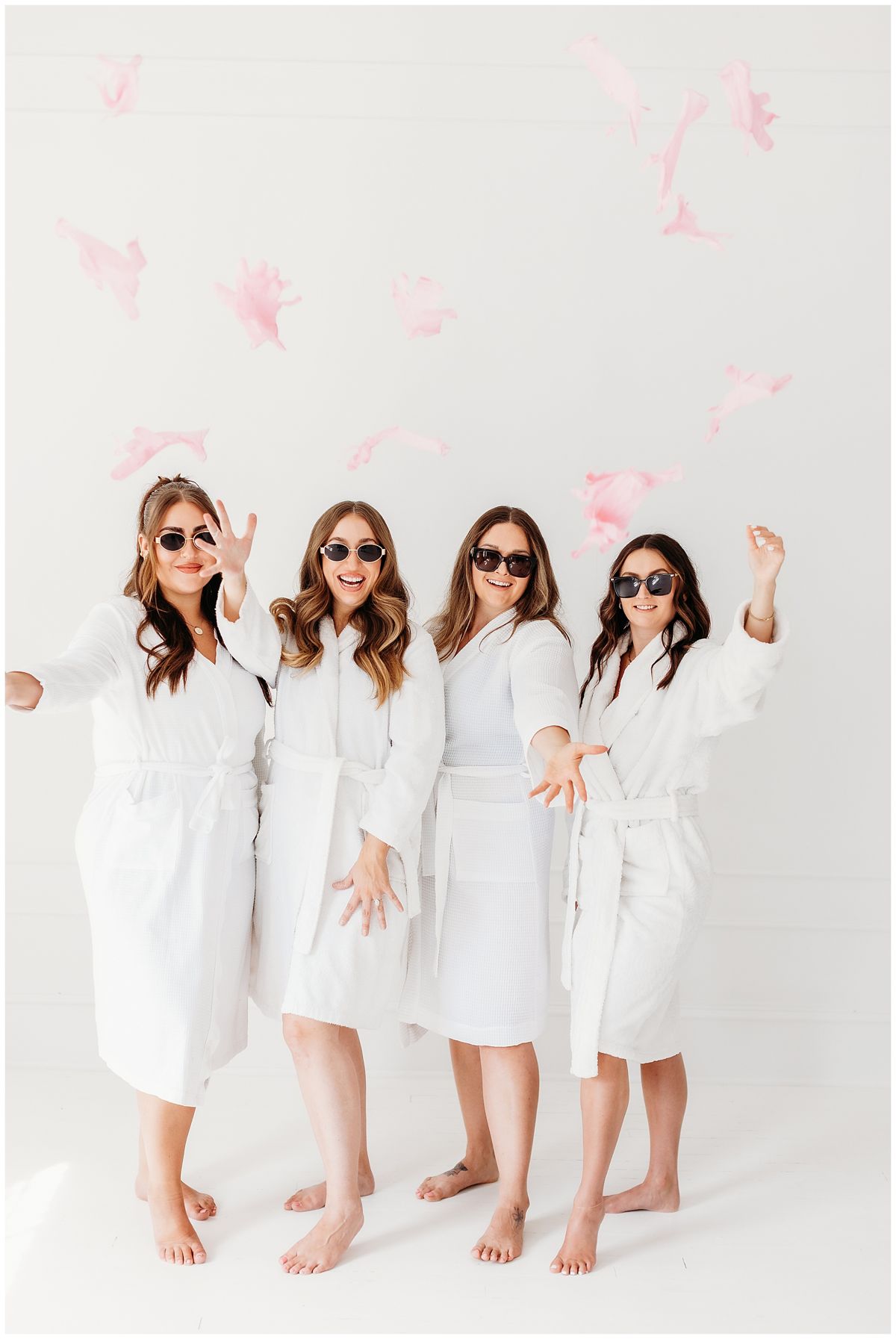 Spa team in white robes with flower petals falling